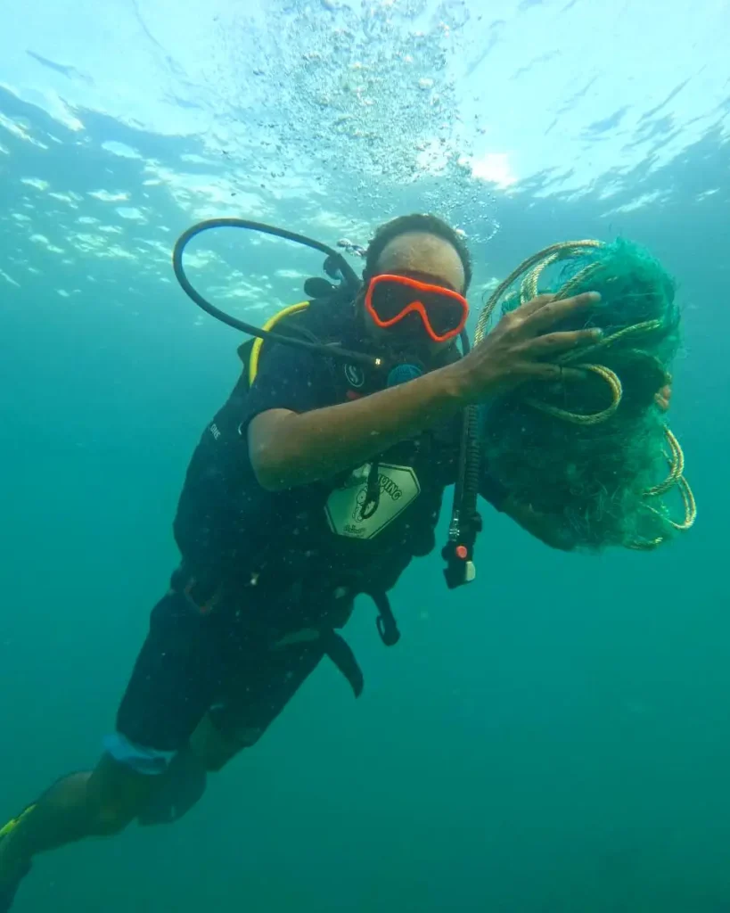 A SCUBA diver removes a fishing net from a reef
